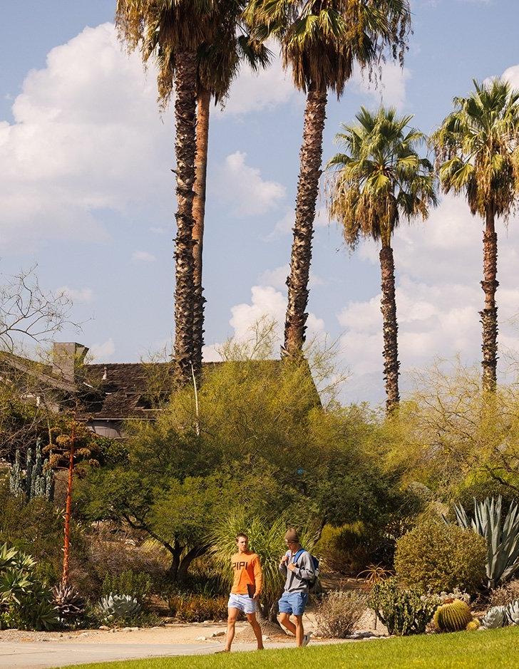 Two student walk past the front of the Grove House